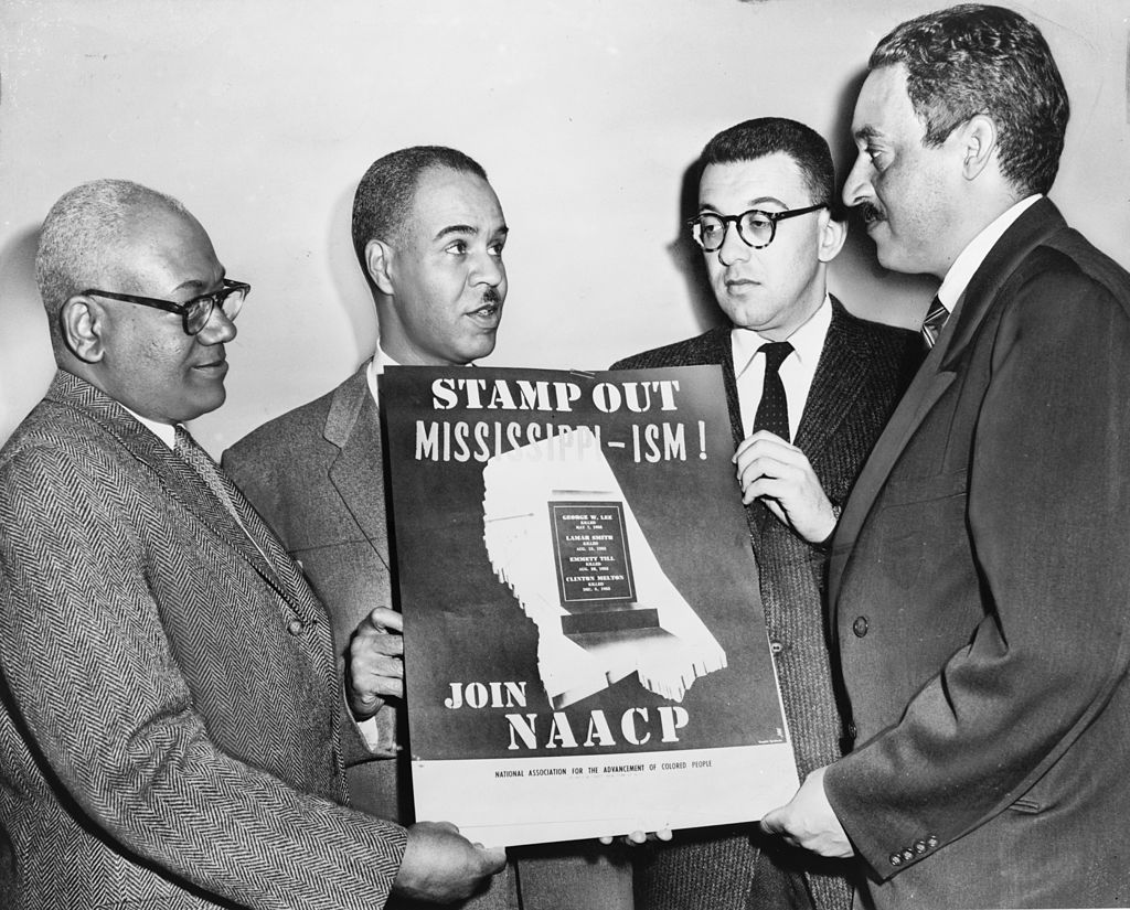 Holding a poster against racial bias in Mississippi in 1956, are four of the most active leaders in the NAACP movement.