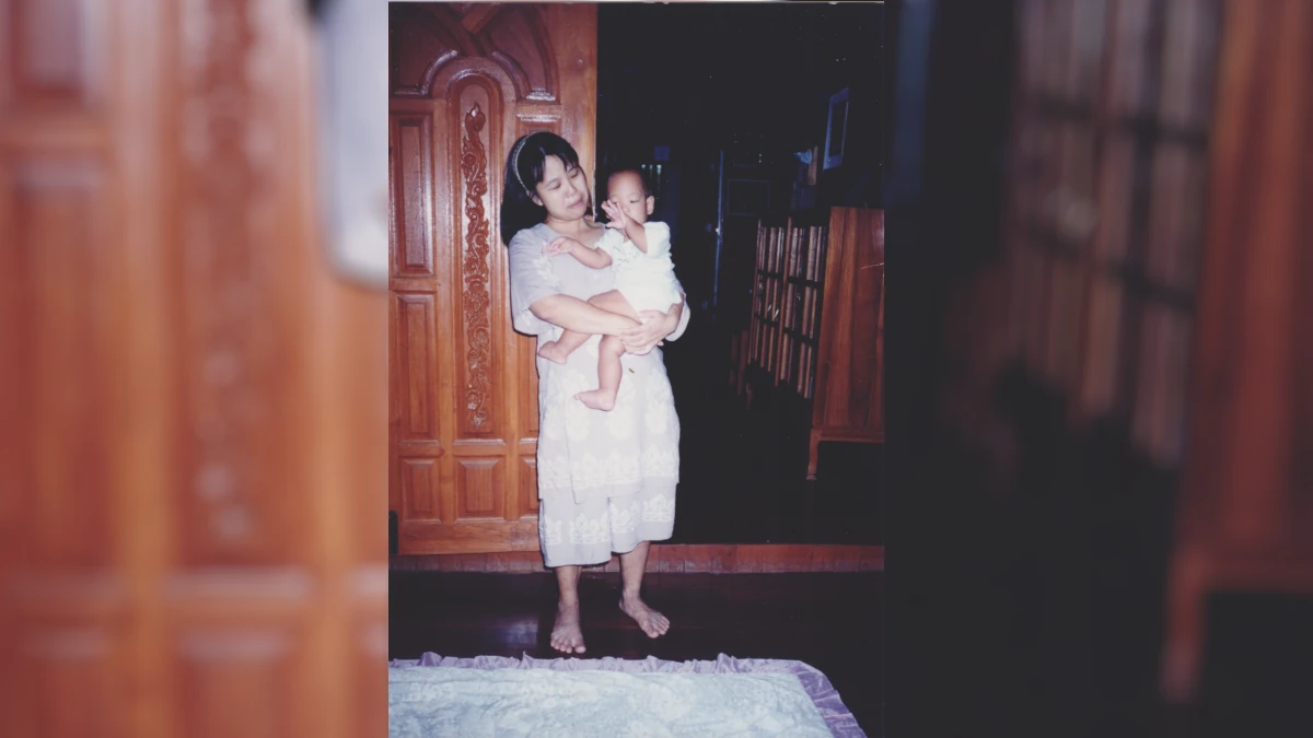 Supermom กำลังยืนอุ้มจิ๊กุ่งขณะที่ยังอยู่ในวัยทารก